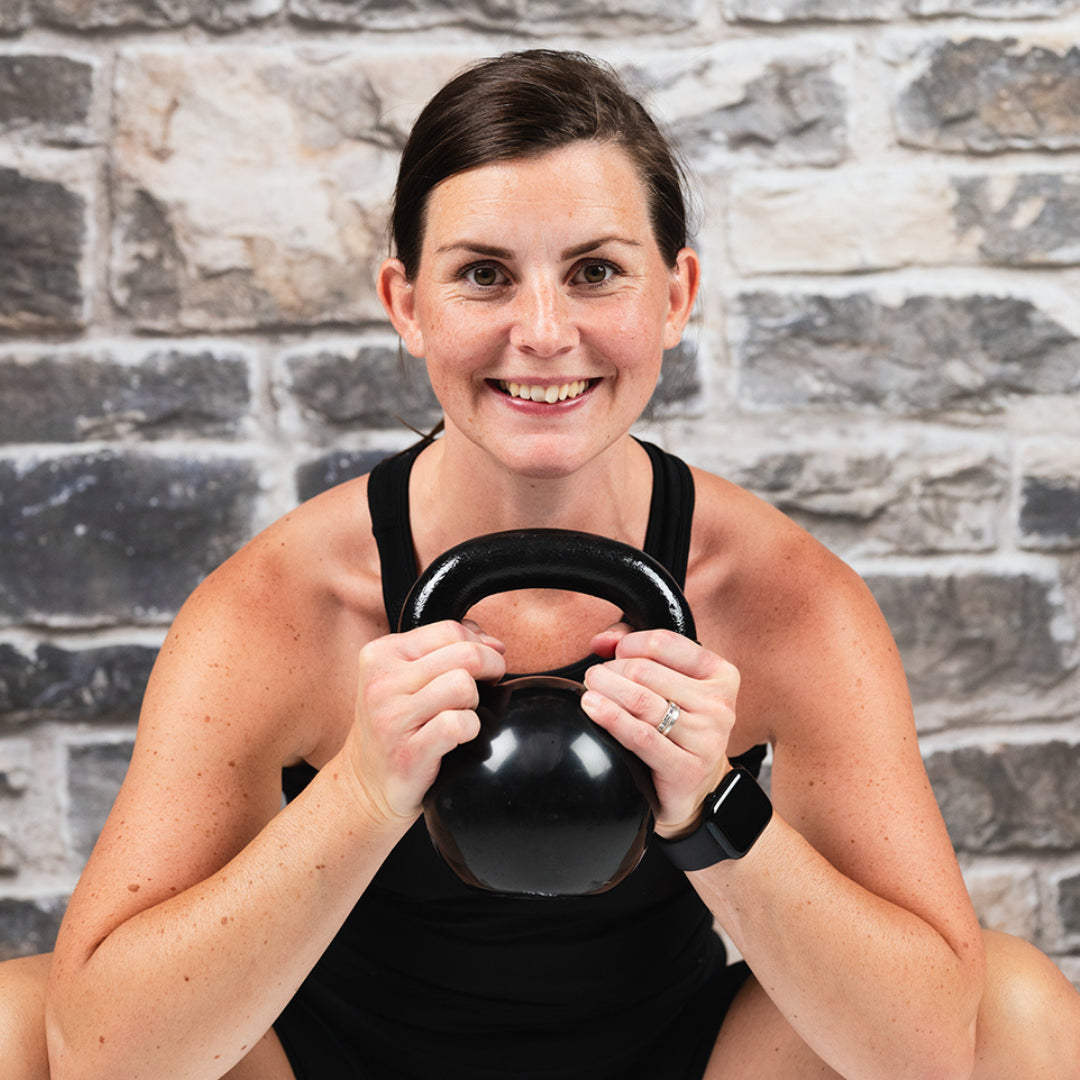 Kvinna tränar kettlebell utomhus i KETTLEBELL – Bodily träningsprogram