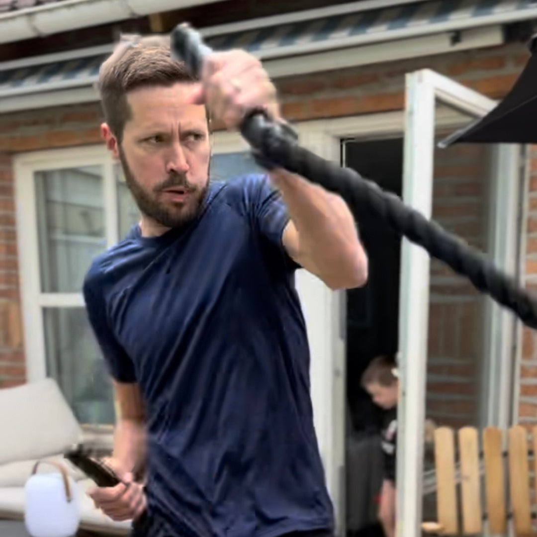 Man som tränar styrka med battle rope som del av Bodily LÖPNING.